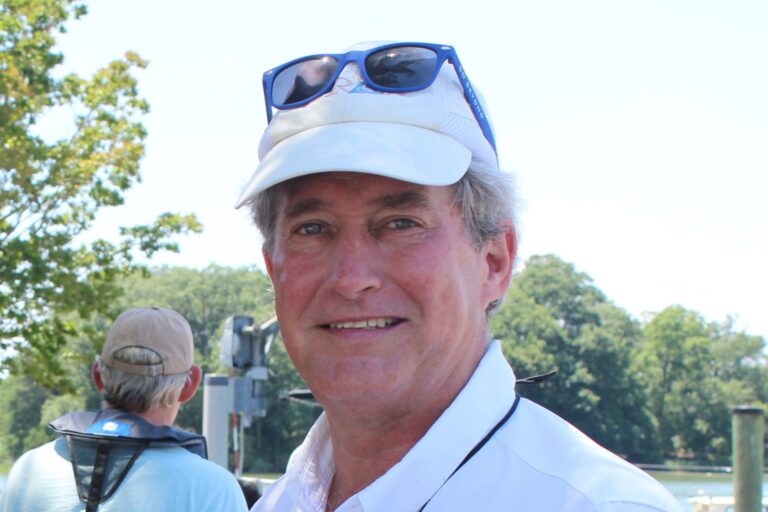 CRAB President and CEO Paul Bollinger Jr. smiling with a CRAB baseball cap on and sunglasses on the top of his head