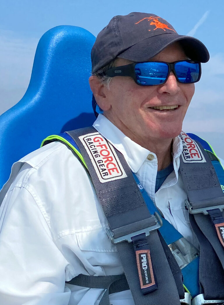 CRAB Board Member and author Steve Ritterbush is seated in one of the bucket seats on a CRAB Beneteau 22 A. He is using the five-point harness system for stability