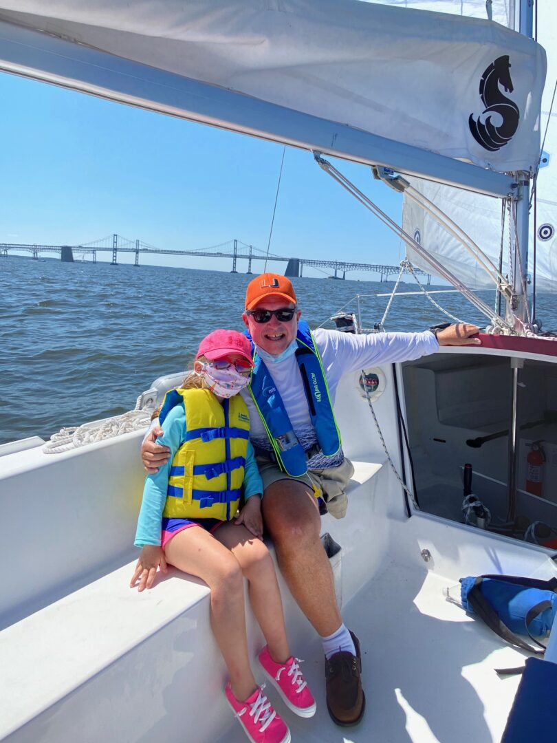 Photo of two guests enjoying a sail on the water in a CRAB sailboat. 