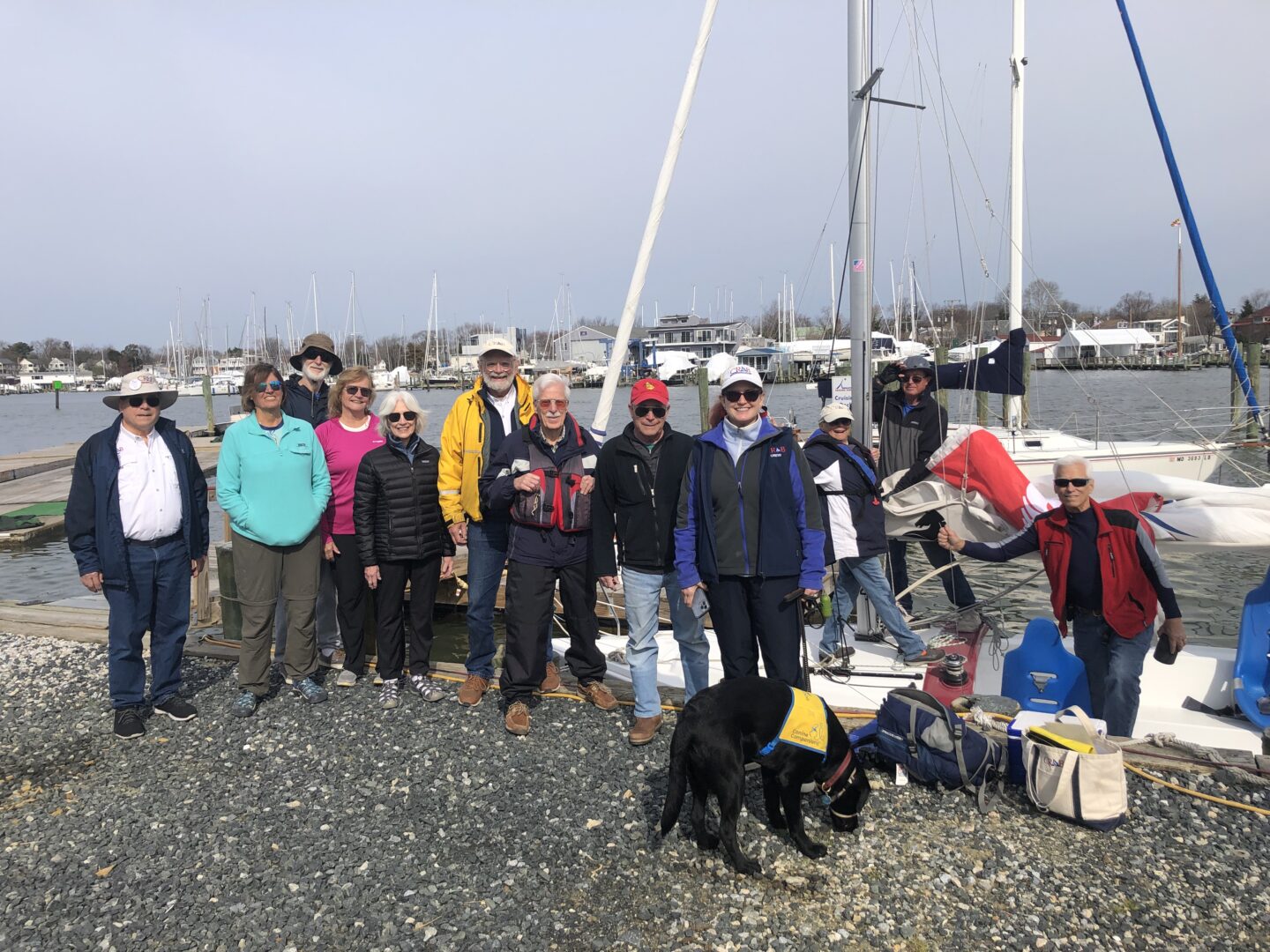 Group photo of CRAB volunteers on dock near CRAB sail boats in the background. 