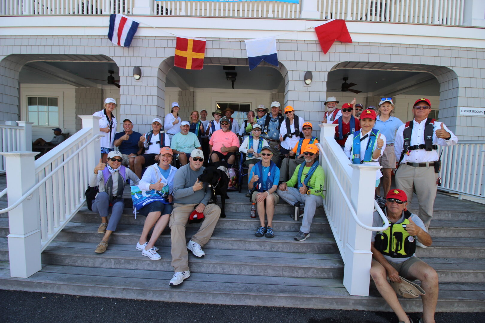 Large group photo of CRAB staff, volunteers, and regatta participants sitting and standing on steps in front of a building. 