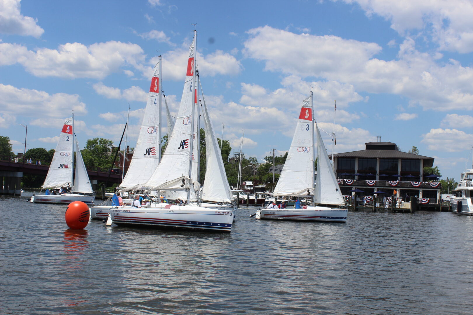Photo of 4 CRAB sailboats in the fleet on the water. 
