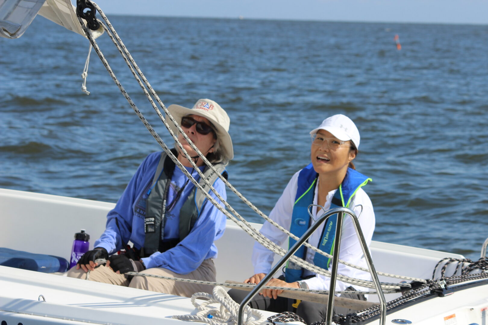 Photo of a CRAB volunteer and guest sailing in one of CRAB's sailboats. 